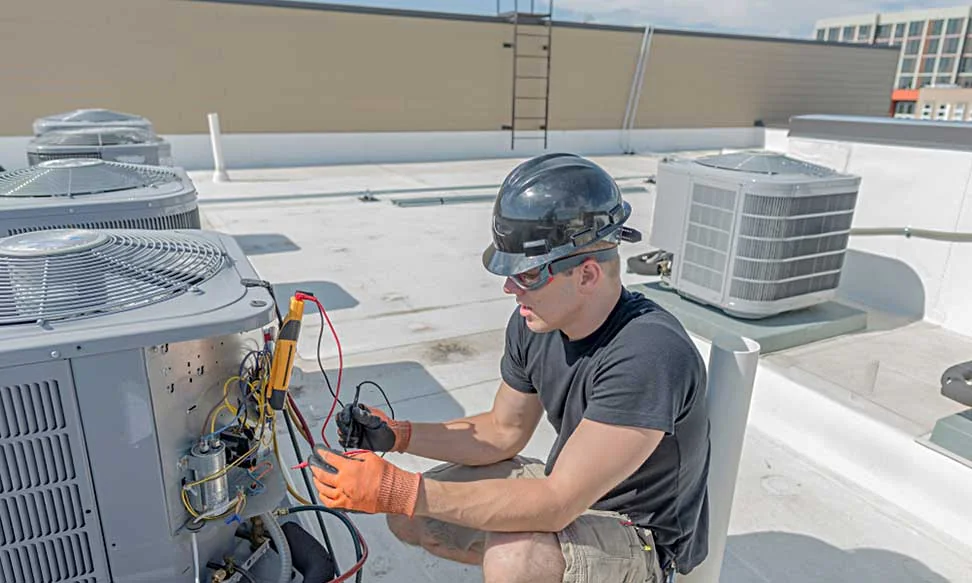 HVAC technician diagnosing rooftop air-conditioning equipment