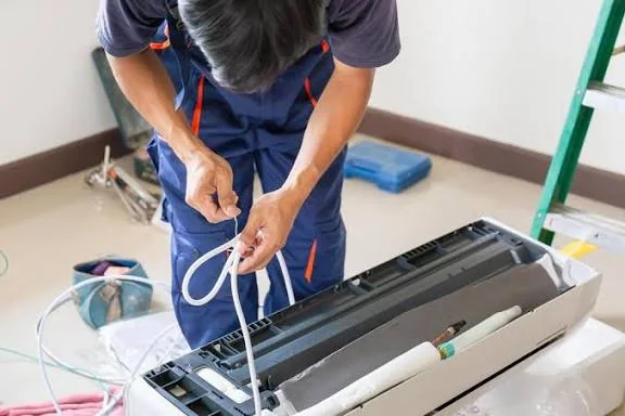 Technician installing and connecting an indoor air-conditioning unit