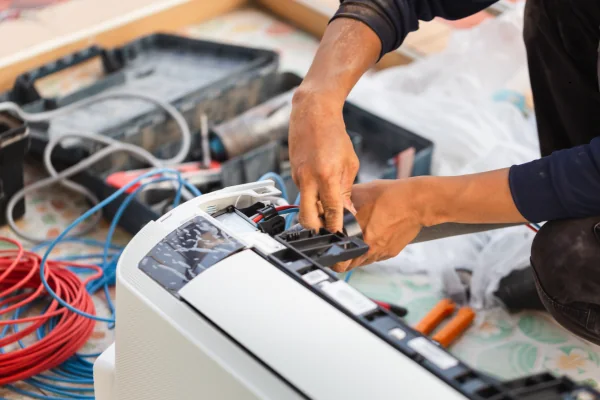Technician connecting controls inside residential climate equipment
